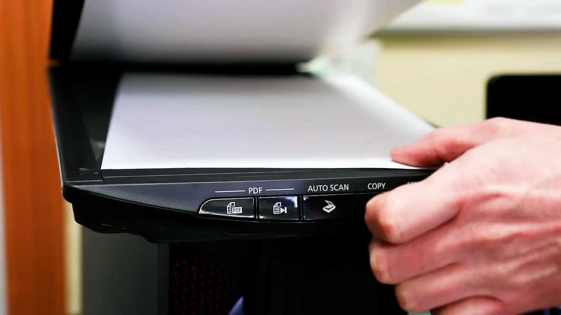 Person placing a document in a scanner.